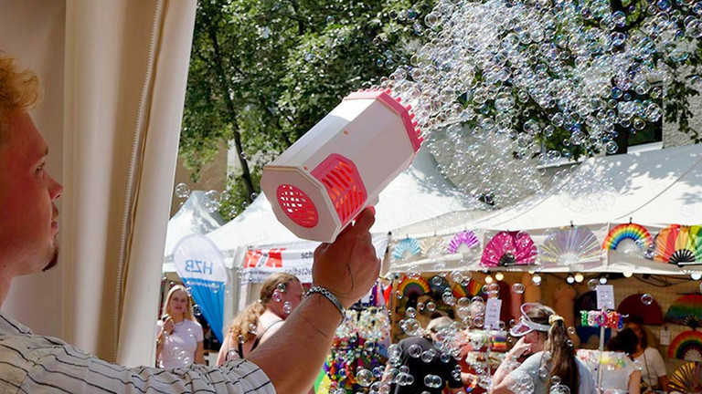 Ein Mitarbeiter der Immanuel Albertinen Diakonie sprüht mit einer Seifenblasenkanone in der Hand zahlreiche Seifenblasen in die Luft beim lesbisch-schwulen Stadtfest Motzstraßenfest rund um den Nollendorfplatz in Berlin-Schöneberg. Ein Mitarbeiter der Immanuel Albertinen Diakonie sprüht mit einer Seifenblasenkanone in der Hand zahlreiche Seifenblasen in die Luft beim lesbisch-schwulen Stadtfest Motzstraßenfest rund um den Nollendorfplatz in Berlin-Schöneberg.