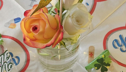 Eine gläserne Vase mit mehreren Rosen auf einem Tisch am Internationalen Tag der Pflegenden. Eine gläserne Vase mit mehreren Rosen auf einem Tisch am Internationalen Tag der Pflegenden.