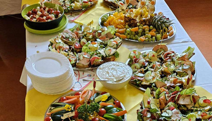 Ein reich gedecktes Buffet mit Obst, Fingerfood, Gemüse, belegten Schnittchen und weißen Tellern am Internationalen Tag der Pflegenden. Ein reich gedecktes Buffet mit Obst, Fingerfood, Gemüse, belegten Schnittchen und weißen Tellern am Internationalen Tag der Pflegenden.