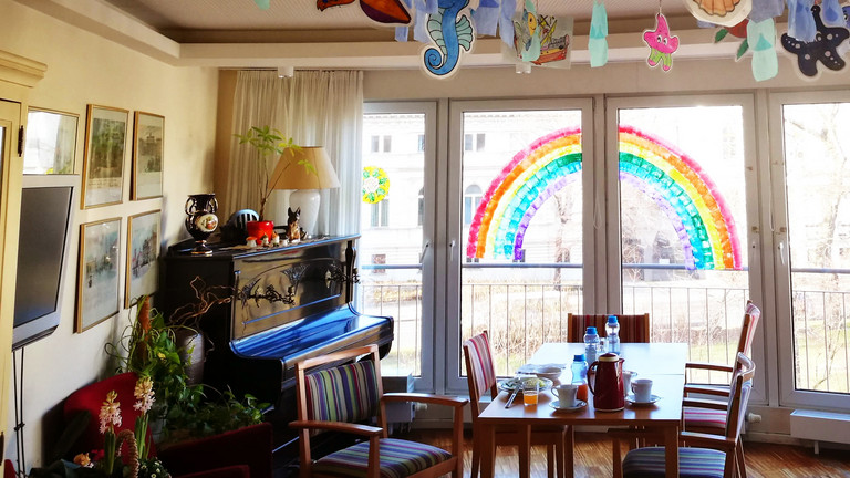  Ein Wohnzimmer mit Regenbogen und Klavier im Immanuel Seniorenzentrum Schöneberg