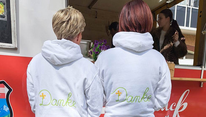 Zwei Mitarbeiterinnen stehen mit hellen Sweatshirts mit der Aufschrift "Danke" vor einem Food-Truck am Internationalen Tag der Pflegenden auf dem Außengelände des Immanuel Klinikums Bernau Herzzentrum Brandenburg. Zwei Mitarbeiterinnen stehen mit hellen Sweatshirts mit der Aufschrift "Danke" vor einem Food-Truck am Internationalen Tag der Pflegenden auf dem Außengelände des Immanuel Klinikums Bernau Herzzentrum Brandenburg.
