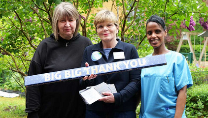 Zwei Pflegekräfte stehen mit Sabine Kalkhoff, Gesamtleiterin Residenz am Wiesenkamp und Gesellschaft für Diakonie, beim Internationalen Tag der Pflegenden mit einem großen Querschild mit der Aufschrift "Big Big Thank You" vor einem Fliederbaum auf dem Außengelände des Feierabendhauses Volksdorf in Hamburg. Zwei Pflegekräfte stehen mit Sabine Kalkhoff, Gesamtleiterin Residenz am Wiesenkamp und Gesellschaft für Diakonie, beim Internationalen Tag der Pflegenden mit einem großen Querschild mit der Aufschrift "Big Big Thank You" vor einem Fliederbaum auf dem Außengelände des Feierabendhauses Volksdorf in Hamburg.