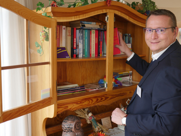 Ehemaliger Einrichtungsleiter Ralf Schäfer vor Bücherschrank